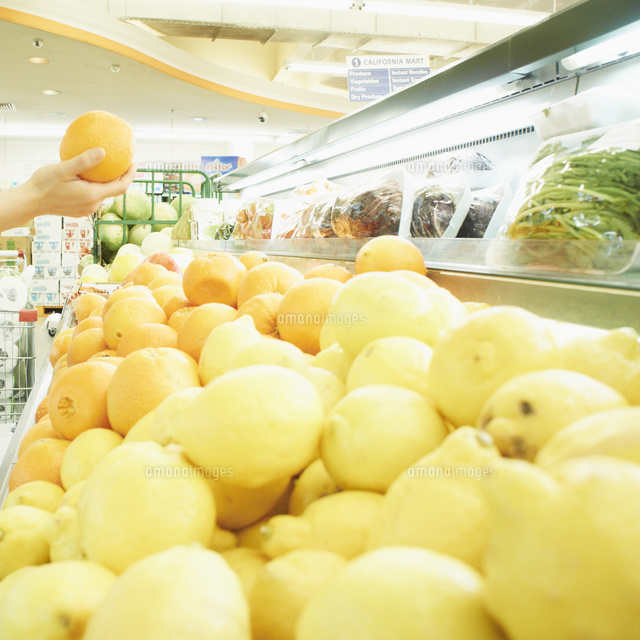 スーパーでオレンジを持つ女性の手元 の写真素材 イラスト素材 アマナイメージズ