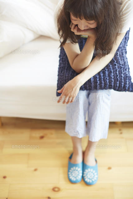 ベッドに座る若い女性 の写真素材 イラスト素材 アマナイメージズ
