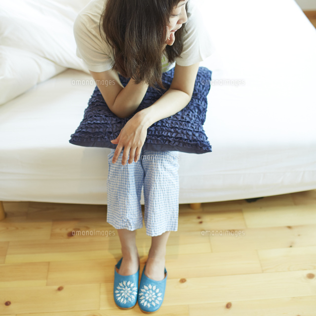 ベッドに座る若い女性 の写真素材 イラスト素材 アマナイメージズ