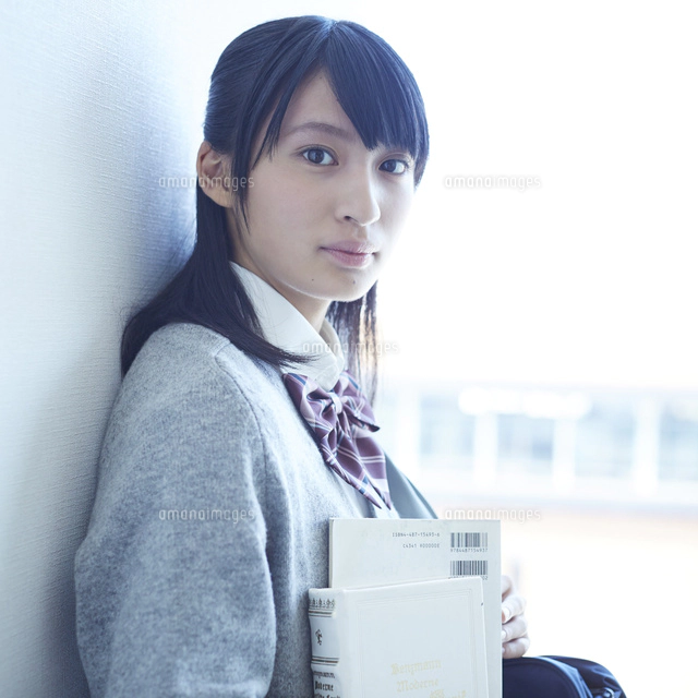 壁に寄りかかる女子学生の横顔 の写真素材 イラスト素材 アマナイメージズ