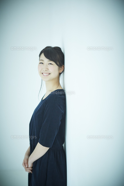 壁に寄りかかる女性 の写真素材 イラスト素材 アマナイメージズ