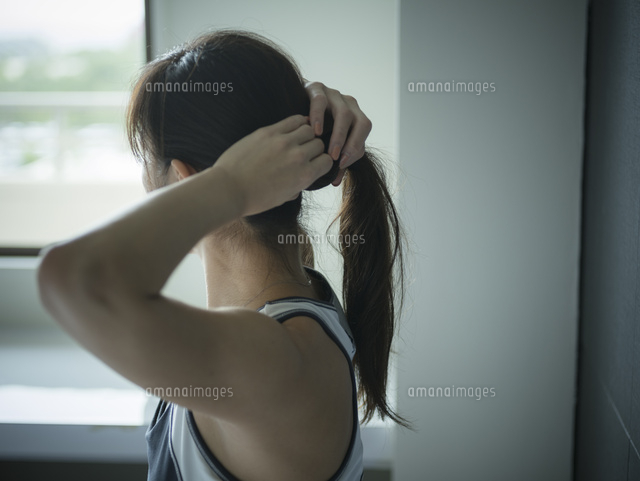 髪を結うトレーニングウェア姿のミドル女性 の写真素材 イラスト素材 アマナイメージズ