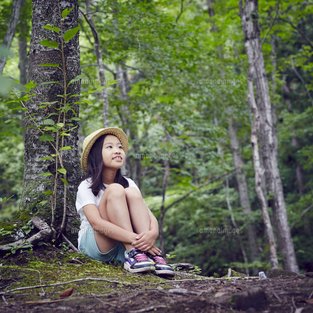 木の根元に座る女の子 の写真素材 イラスト素材 アマナイメージズ