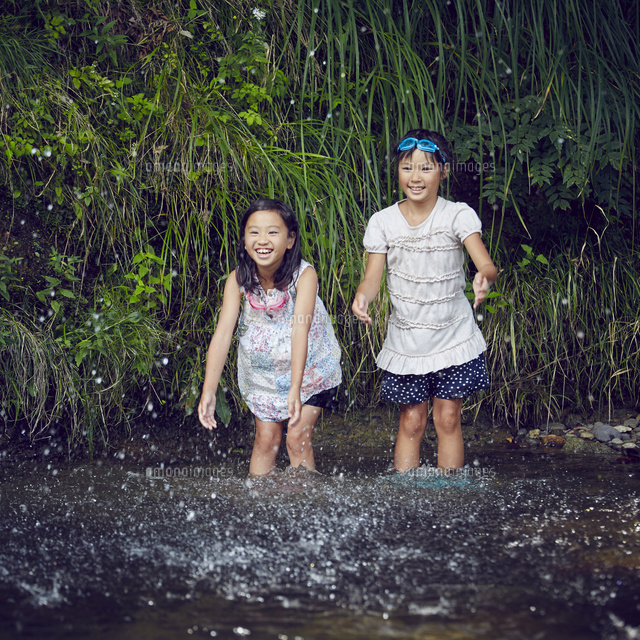 川遊びをする女の子2人と水しぶき の写真素材 イラスト素材 アマナイメージズ