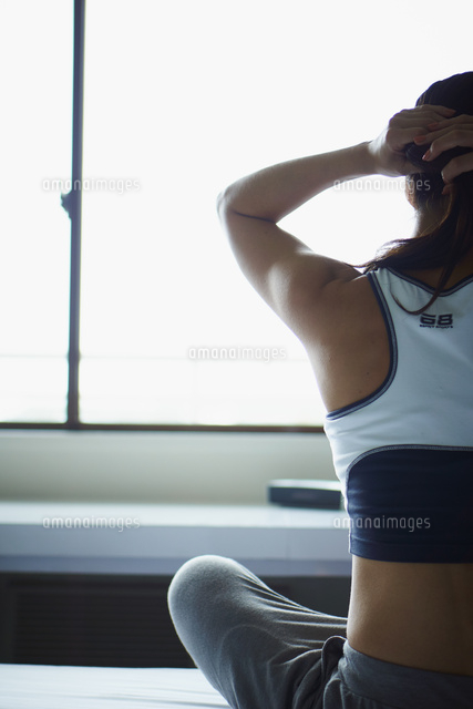 髪を結うトレーニングウェア姿のミドル女性 の写真素材 イラスト素材 アマナイメージズ