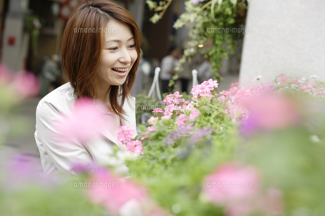 フラワーショップの花を見る女性 の写真素材 イラスト素材 アマナイメージズ