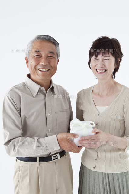 プレゼントを持つシニアカップル の写真素材 イラスト素材 アマナイメージズ