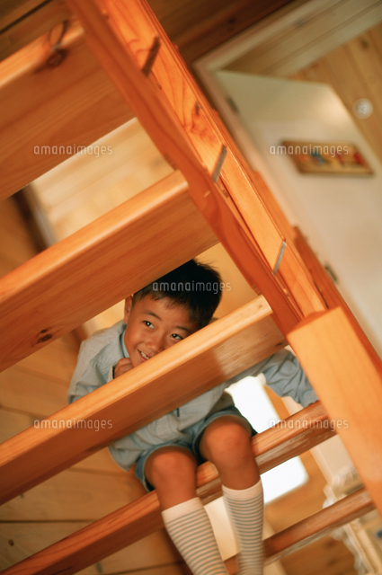 階段の隙間からのぞく男の子 の写真素材 イラスト素材 アマナイメージズ
