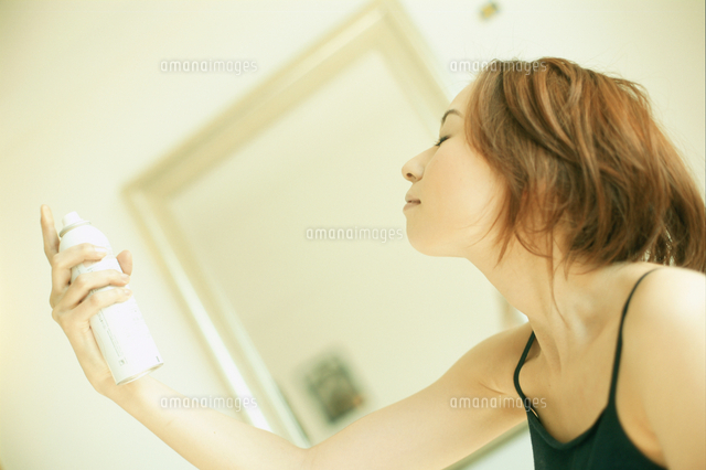 顔にスプレーする女性 の写真素材 イラスト素材 アマナイメージズ
