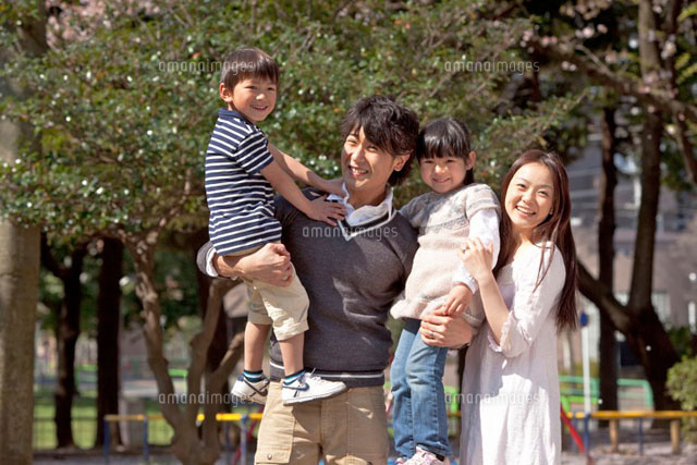 公園で男女2人の子供を抱く父親と寄り添う母親 の写真素材 イラスト素材 アマナイメージズ