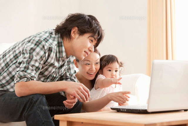 パソコンの画面を見つめる赤ちゃんと若い夫婦 の写真素材 イラスト素材 アマナイメージズ