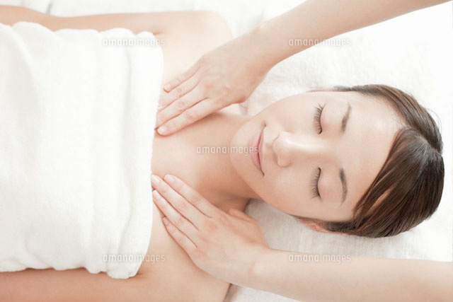 仰向けで肩をマッサージされている若い女性 の写真素材 イラスト素材 アマナイメージズ