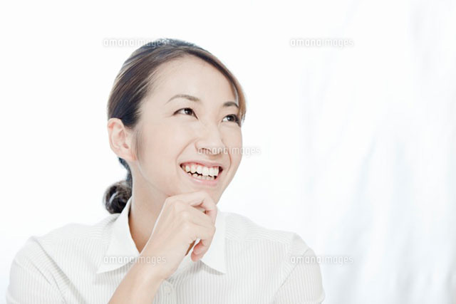 笑顔で顎に手をやる若い女性 の写真素材 イラスト素材 アマナイメージズ