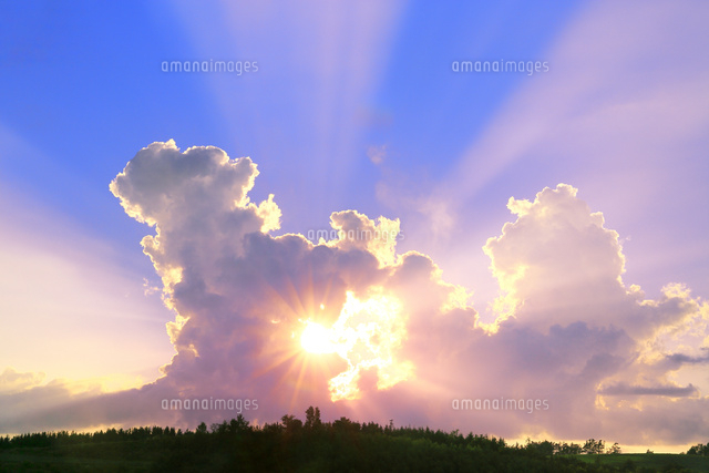 入道雲と夕日に光芒 の写真素材 イラスト素材 アマナイメージズ