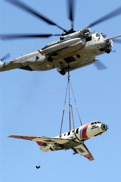 A CH-53 Sea Stallion lifts a HU-25 Guardian Coast Guard airc