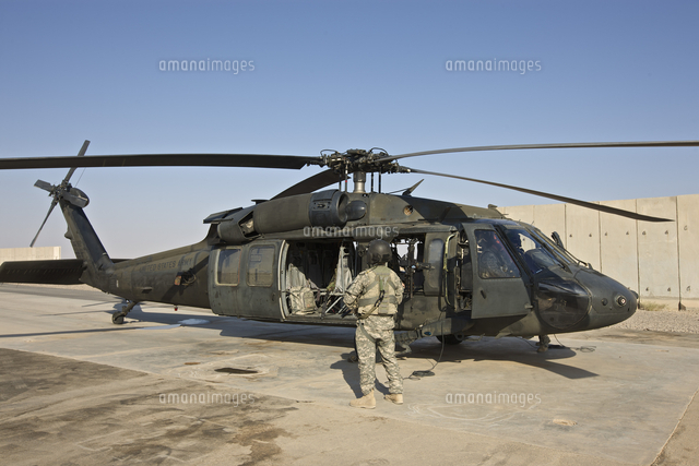 A U.S. Army crew chief stands next to a UH-60 Black Hawk