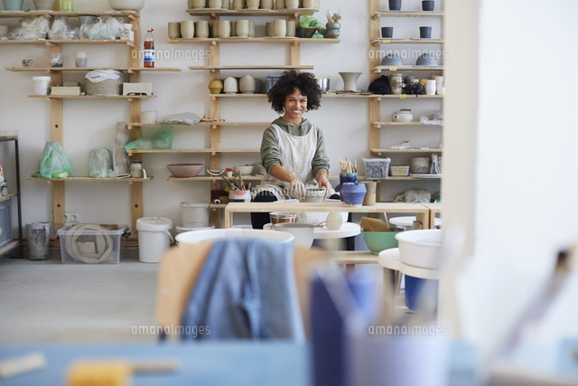 Portrait of smiling woman learning pottery in art studio[11081032250]の ...