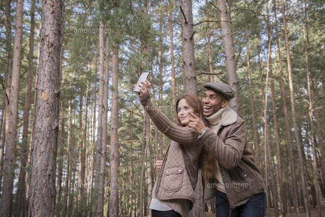 A young couple taking a selfie on a forest walk in Autumn.[11082001072 ...