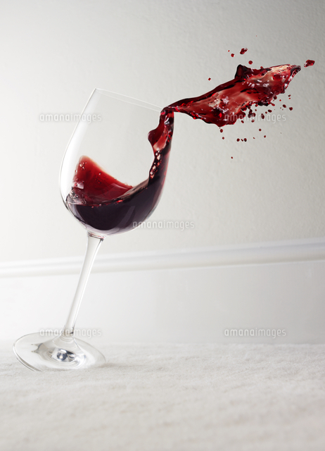 Glass of red wine spilling[11086002375]の写真・イラスト素材