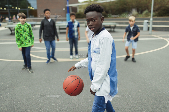 Portrait Confident Tween Boy Playing Basketball In Schoolyard の写真素材 イラスト素材 アマナイメージズ