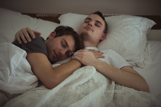 Gay Couple Embracing While Sleeping On Bed の写真素材 イラスト素材 アマナイメージズ