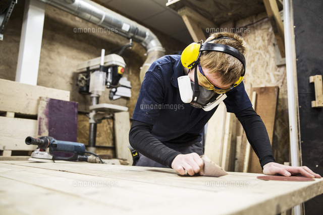 Man Wearing Ear Protectors Protective Goggles And Dust Mask Standing In A Warehouse Working On A P の写真素材 イラスト素材 アマナイメージズ