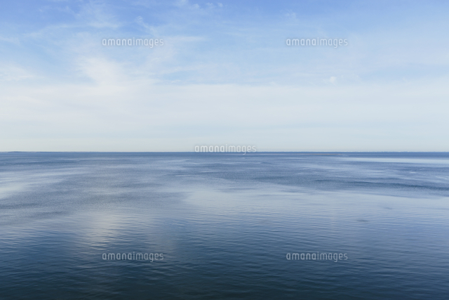 View out to the open sea from the coast. Flat calm water surface