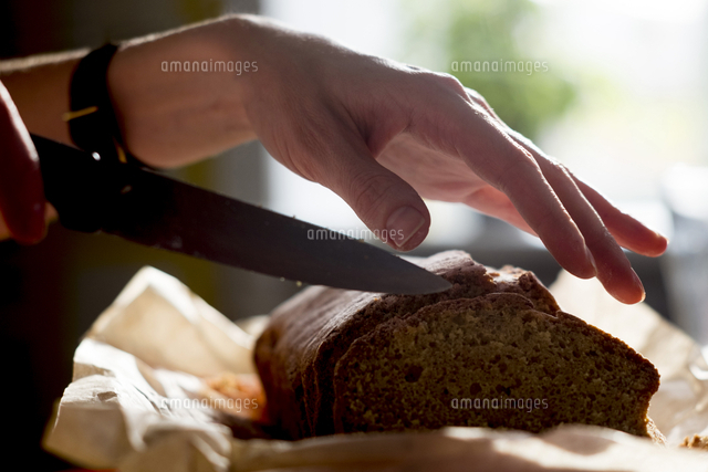 Cropped hands of woman cutting cake slices at home[11100062926]の写真素材 ...