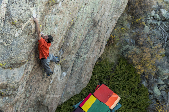 Athletic Male Climbs Outside On A Tall Boulder Above Crash Pads の写真素材 イラスト素材 アマナイメージズ