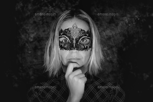 Close Up Portrait Of Young Woman Wearing Masquerade Mask Against Wall の写真素材 イラスト素材 アマナイメージズ