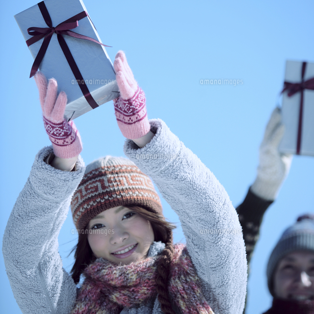 プレゼントを持ち上げるカップル の写真素材 イラスト素材 アマナイメージズ