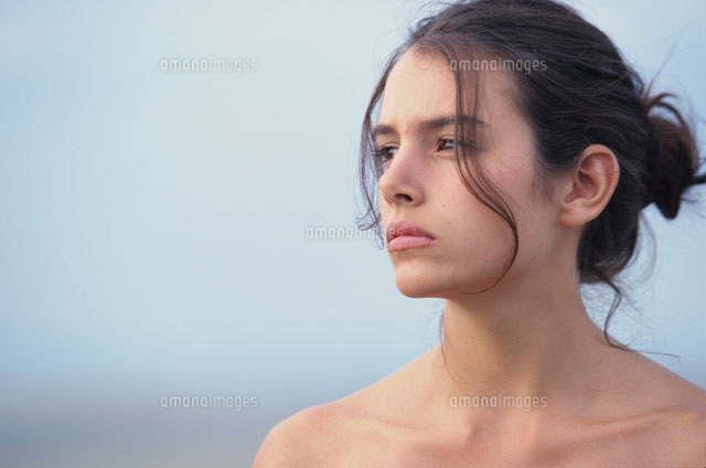 海辺で髪をまとめた女性の横顔[21007004318]の写真・イラスト