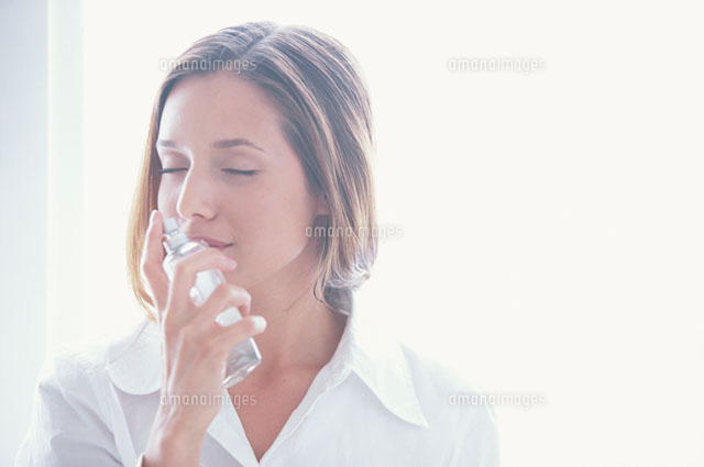 顔にスプレーする女性 の写真素材 イラスト素材 アマナイメージズ