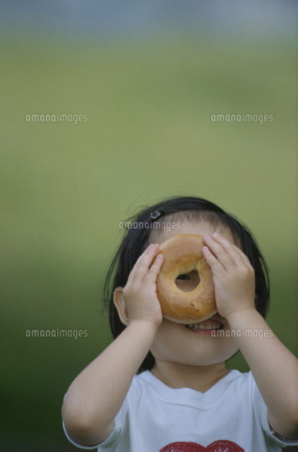 ベーグルの穴から覗く女の子 の写真素材 イラスト素材 アマナイメージズ