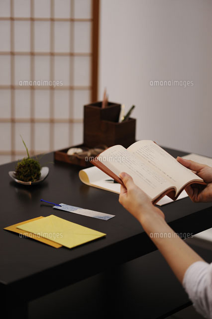 机の上で本を読む女性の手元 の写真素材 イラスト素材 アマナイメージズ