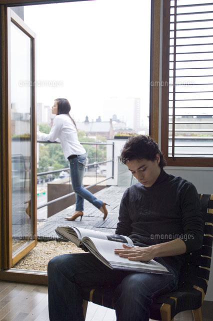 ベランダの女性とイスに座って本を読む男性 21090001600 の写真素材 イラスト素材 アマナイメージズ