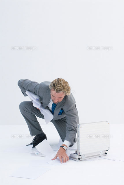 落ちた書類を拾うビジネスマン b の写真素材 イラスト素材 アマナイメージズ