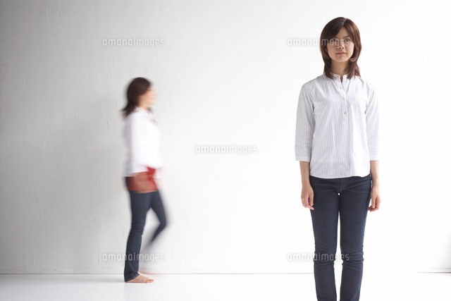 立っている女性と後ろを歩く女性 の写真素材 イラスト素材 アマナイメージズ