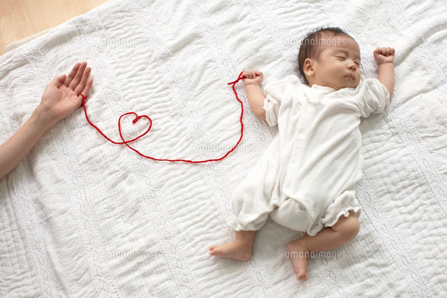 寝ている赤ちゃんとおかあさんを結ぶ赤い糸 の写真素材 イラスト素材 アマナイメージズ
