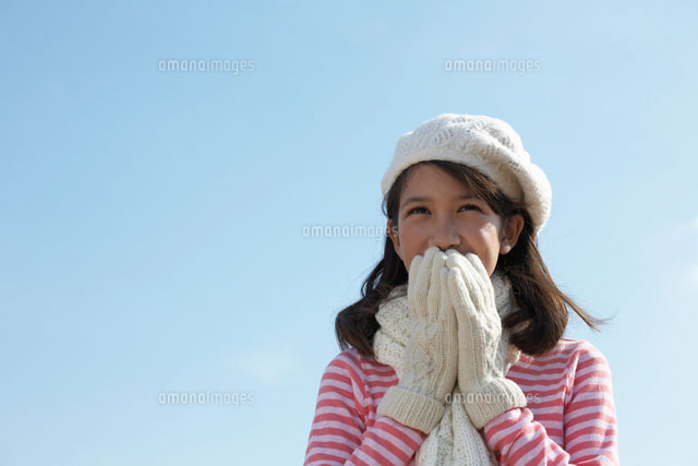 手袋とマフラーをして寒そうにする女の子と青空 の写真素材 イラスト素材 アマナイメージズ