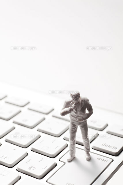 キーボードのエンターの上で考えるフィギュア の写真素材 イラスト素材 アマナイメージズ
