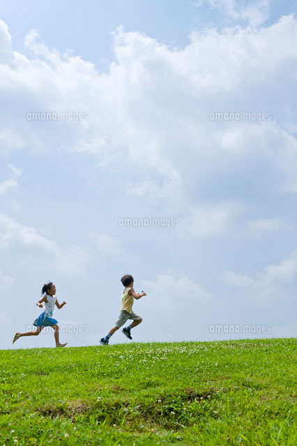 丘の上を走る子ども の写真素材 イラスト素材 アマナイメージズ