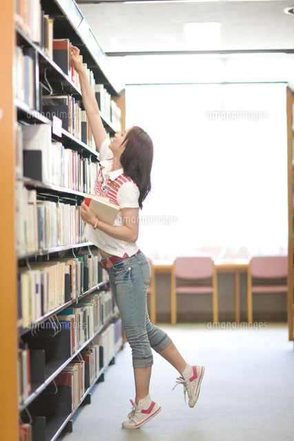 図書室で本を探す女性 a の写真素材 イラスト素材 アマナイメージズ