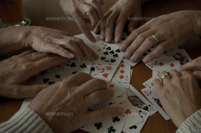 トランプのカードをシャッフルする4人の手元[24007000743]の写真