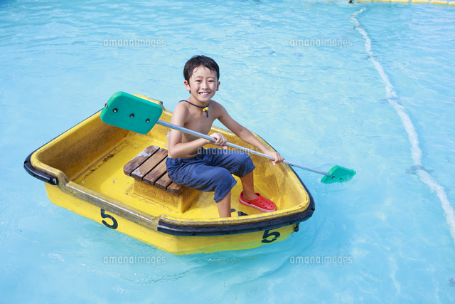 プールでボートを漕ぐ男の子 の写真素材 イラスト素材 アマナイメージズ