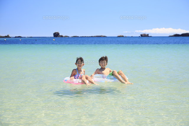 海で浮き輪に乗って浮かぶ兄妹 の写真素材 イラスト素材 アマナイメージズ
