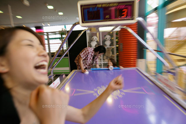 ゲームセンターで遊ぶ男女 の写真素材 イラスト素材 アマナイメージズ