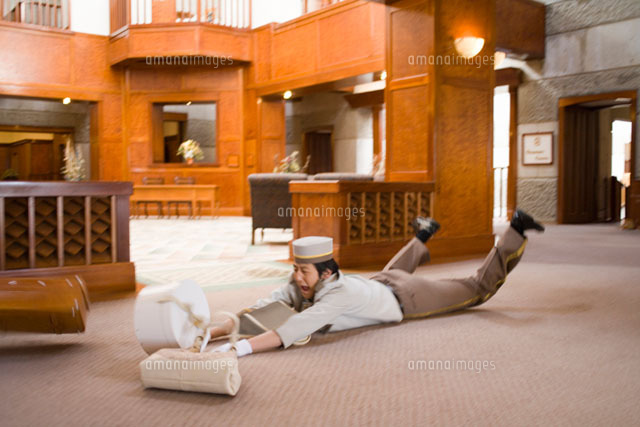 転んで荷物をぶちまけるホテルマン の写真素材 イラスト素材 アマナイメージズ