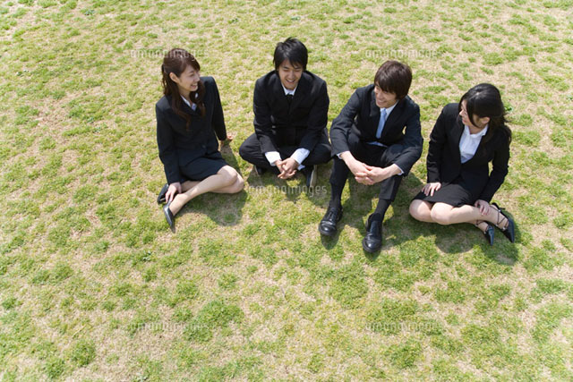 芝生に座る新社会人4人 の写真素材 イラスト素材 アマナイメージズ