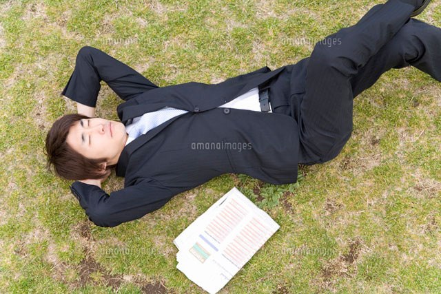 芝生に寝転ぶ男性 の写真素材 イラスト素材 アマナイメージズ